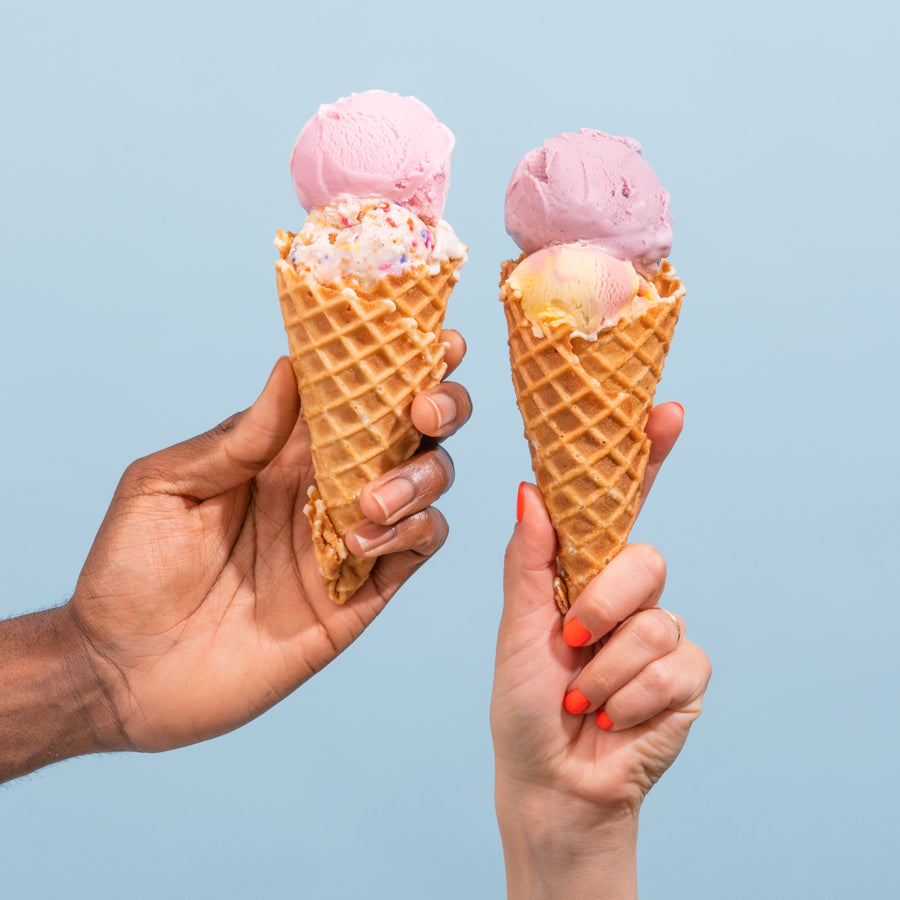 Two hands holding ice cream cones