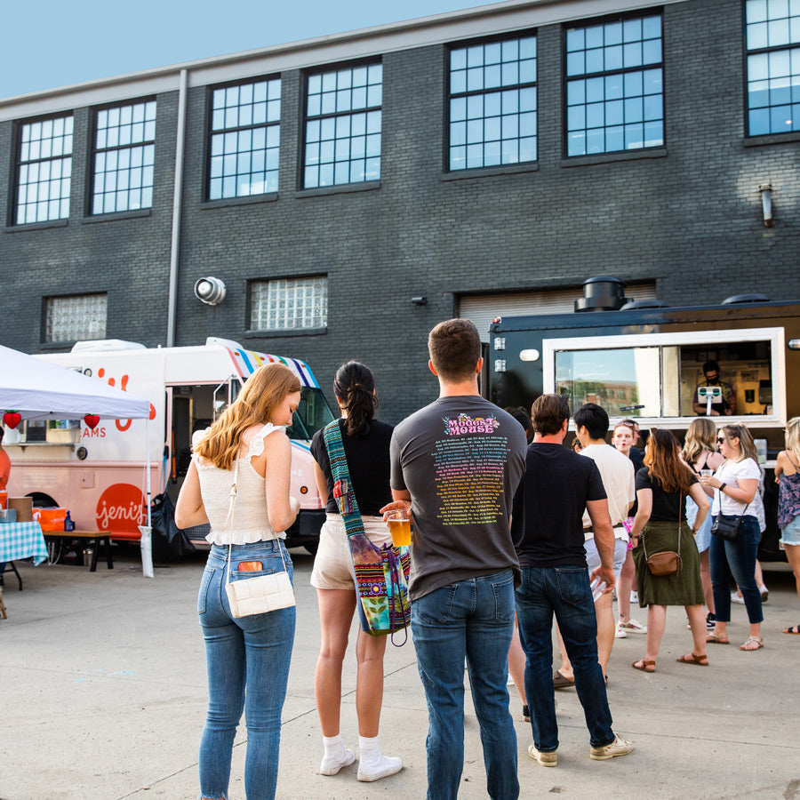 People standing in line outside of Land Grant brewery