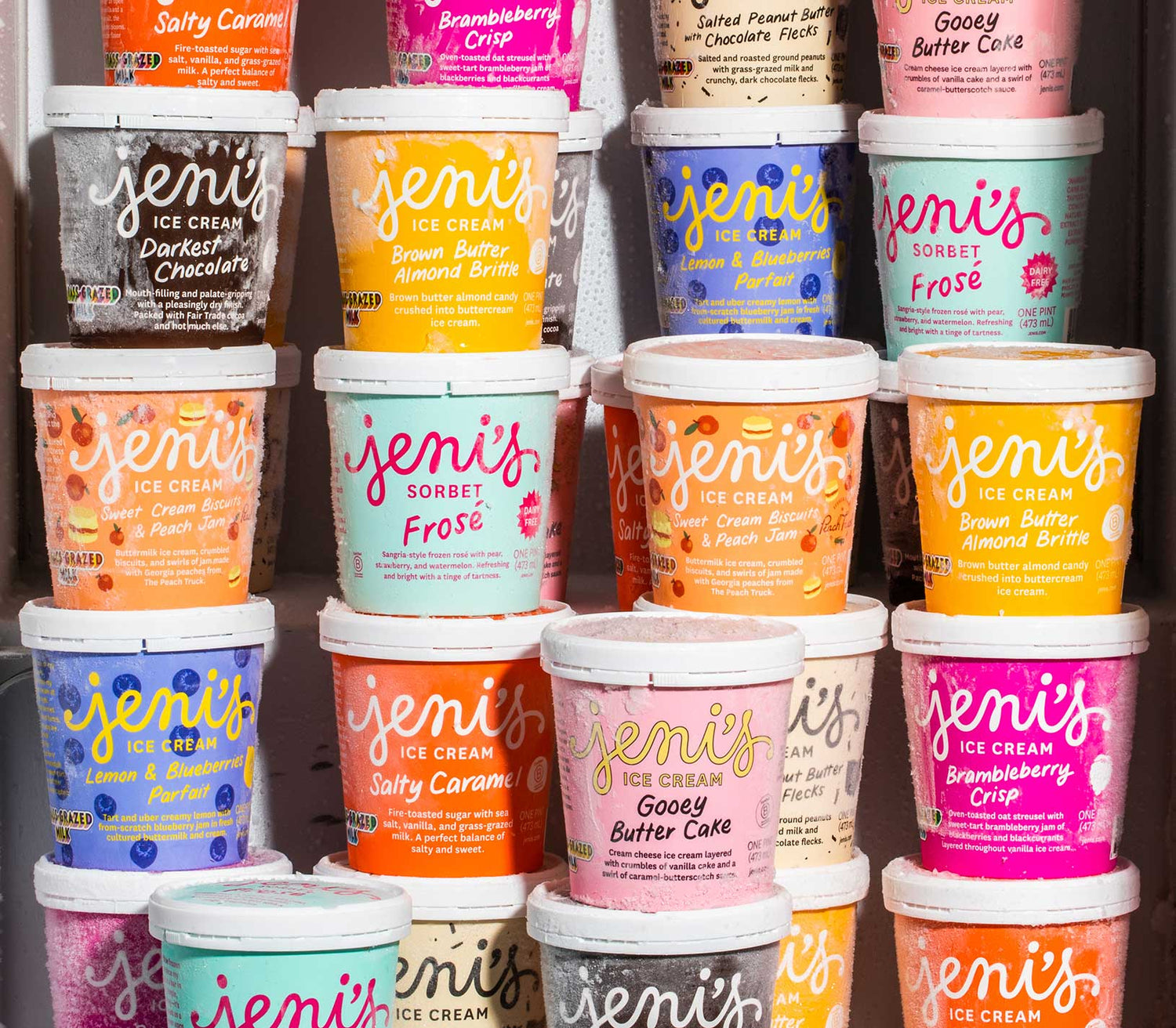 A close up photo of a freezer full of pints of Jeni's ice cream in a variety of flavors.