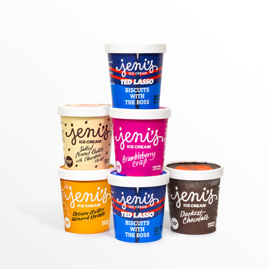 Six pints of Jeni's Splendid Ice Creams arranged in a pyramid on a white background, including two navy Ted Lasso 'Biscuits with the Boss' pints, plus Salted Peanut Butter with Chocolate Flecks, Brambleberry Crisp, Brown Butter Almond Brittle, and Darkest Chocolate.
